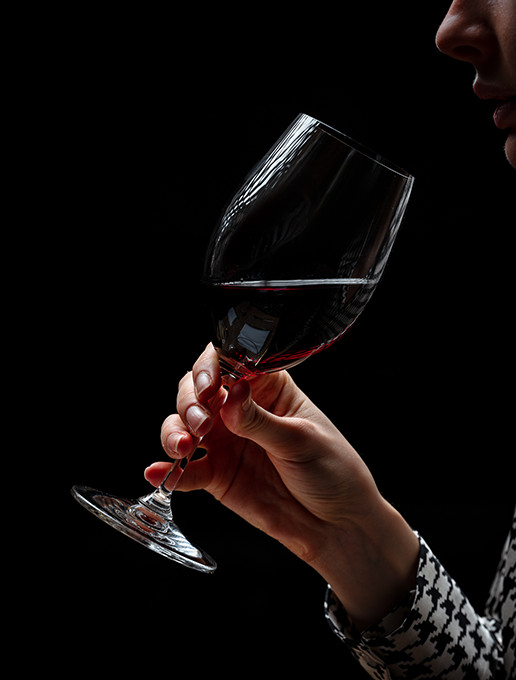 A woman enjoying a glass of wine in an intimate setting to celebrate Christmas at Dans le Noir ?