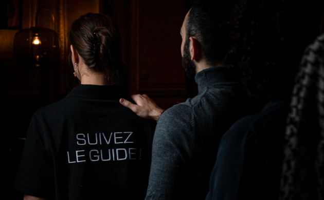 a person holding the shoulder of their blind guide before entering the Dans le Noir ? experience