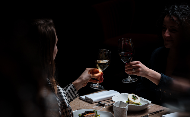 Two people sharing a dinner in total darkness at Dans le Noir ?, enjoying a unique sensory dining experience